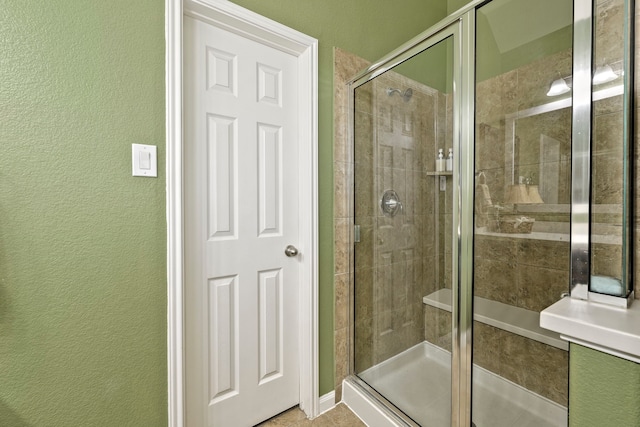 full bath with a shower stall and a textured wall