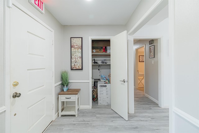 hall featuring light wood-type flooring and baseboards