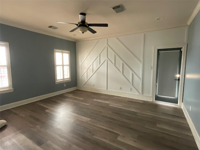 unfurnished room with visible vents, dark wood-style flooring, ceiling fan, and crown molding