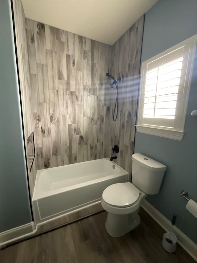 full bath featuring wood finished floors, toilet, tub / shower combination, and baseboards