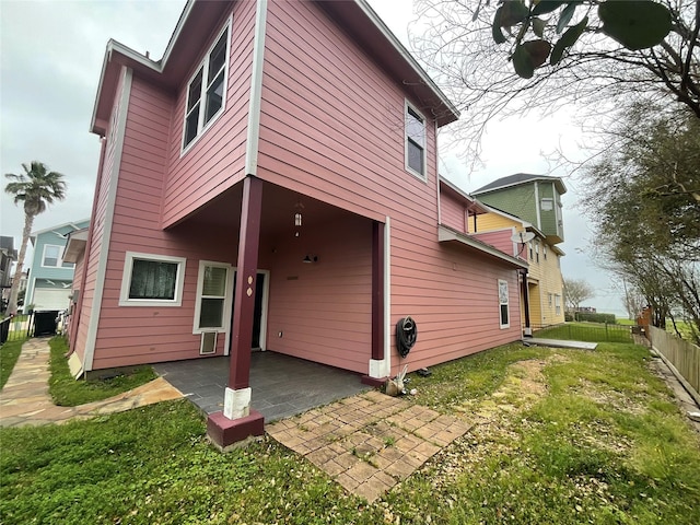 back of house with a patio area, a lawn, and fence