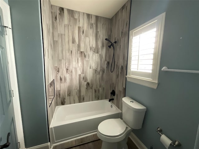 bathroom featuring baseboards, toilet, and  shower combination