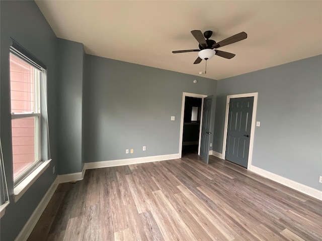 unfurnished room featuring wood finished floors, baseboards, and ceiling fan