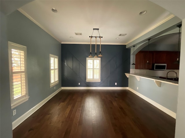 unfurnished dining area featuring visible vents, crown molding, baseboards, and dark wood-style flooring