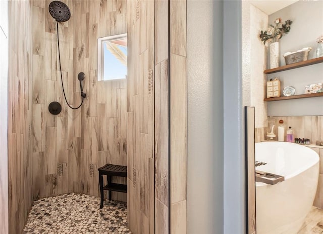 full bath with a soaking tub and a tile shower