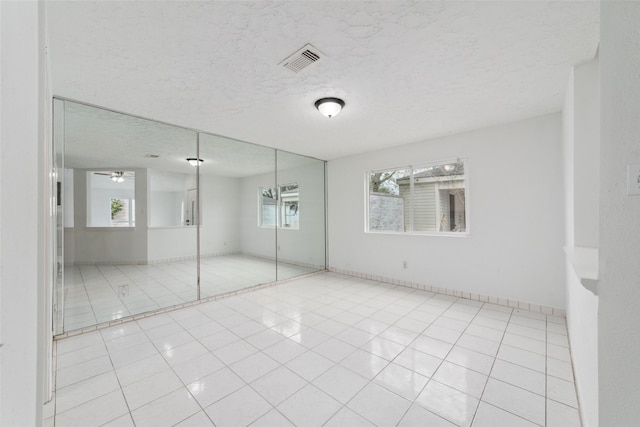 16123 Ridgegreen Dr, Houston, TX 77082 - unfurnished bedroom with light tile patterned floors, visible vents, a textured ceiling, and a closet