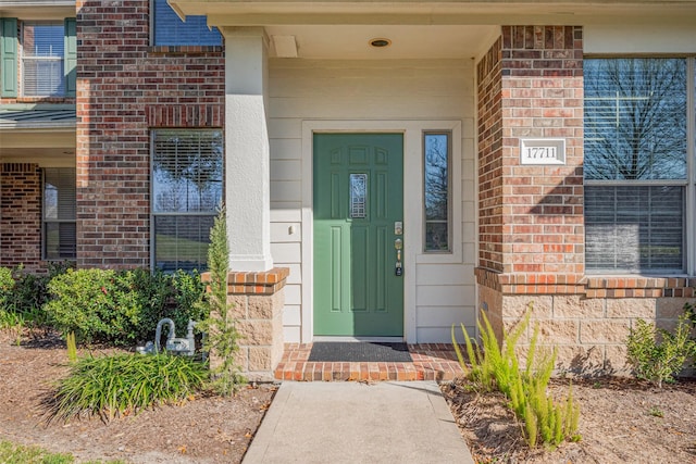 entrance to property featuring brick siding