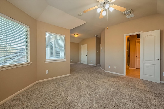 carpeted spare room featuring ceiling fan, lofted ceiling, and baseboards
