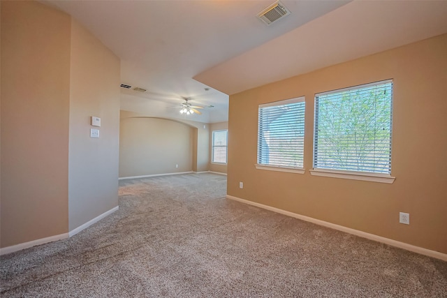 spare room with carpet, a ceiling fan, and baseboards