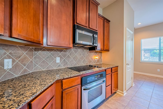 kitchen featuring stainless steel oven, black electric cooktop, light tile patterned floors, and brown cabinets