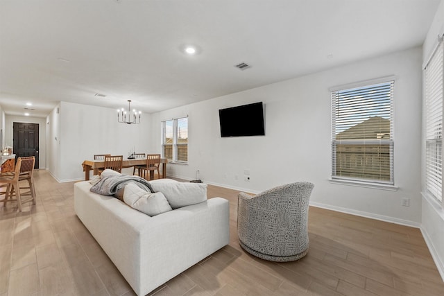 living area with baseboards, visible vents, an inviting chandelier, recessed lighting, and light wood-type flooring