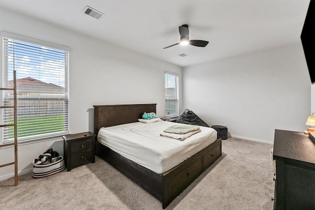 bedroom with visible vents, baseboards, light colored carpet, and a ceiling fan