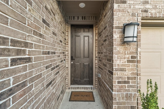 property entrance featuring brick siding