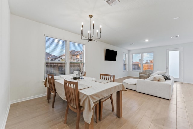 dining space featuring visible vents, baseboards, and an inviting chandelier