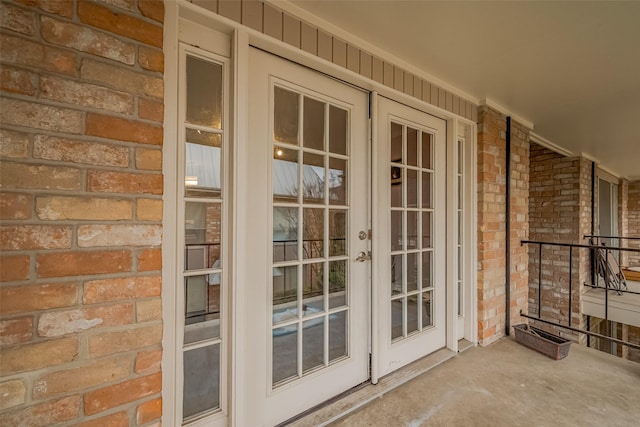 entrance to property featuring french doors and brick siding