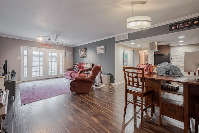 living area featuring wood finished floors, visible vents, baseboards, french doors, and crown molding