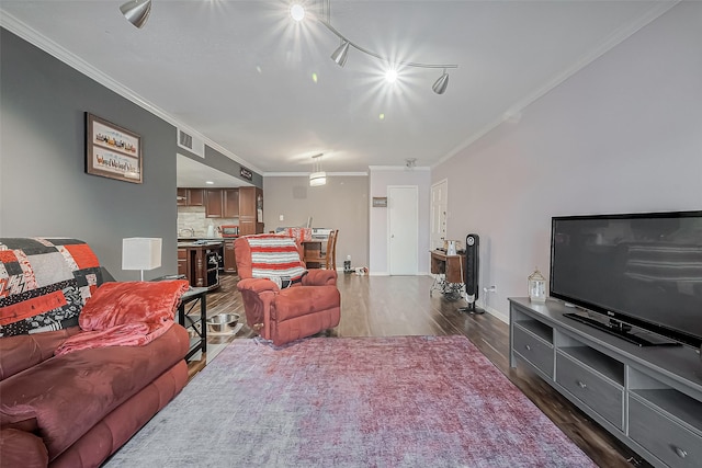 living room featuring visible vents, baseboards, dark wood-type flooring, and crown molding