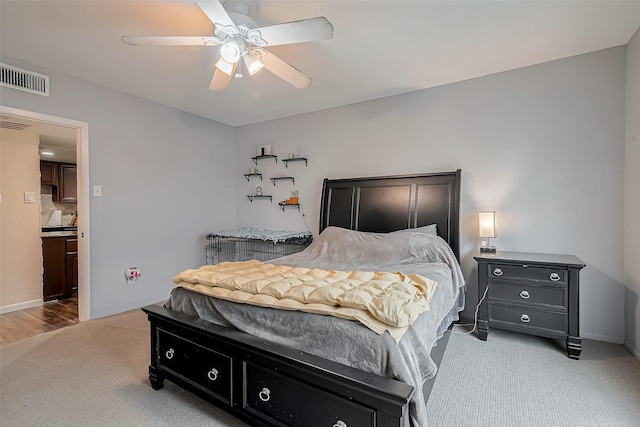 bedroom featuring a ceiling fan, light colored carpet, and visible vents