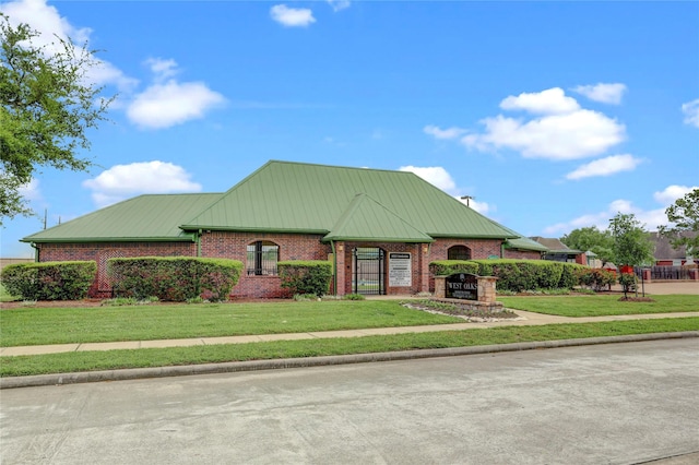 view of front facade with brick siding and a front lawn
