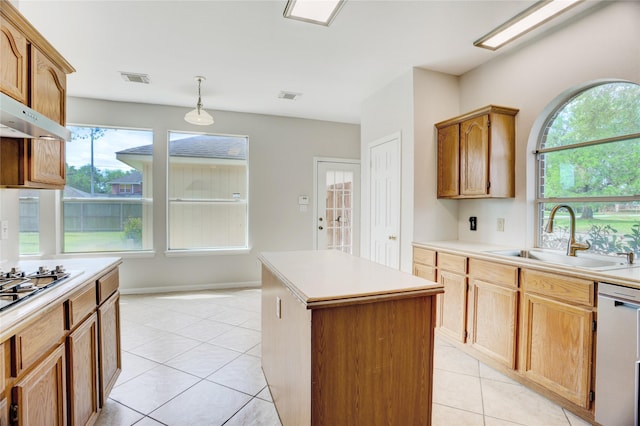 kitchen with a center island, light countertops, a sink, dishwasher, and light tile patterned floors