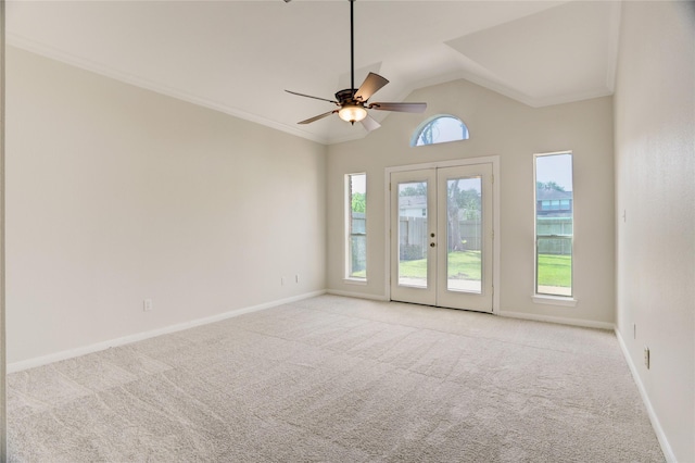 empty room with vaulted ceiling, carpet floors, baseboards, and ceiling fan