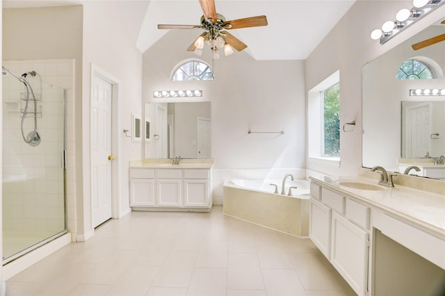 bathroom featuring a wealth of natural light, a ceiling fan, a stall shower, and a sink