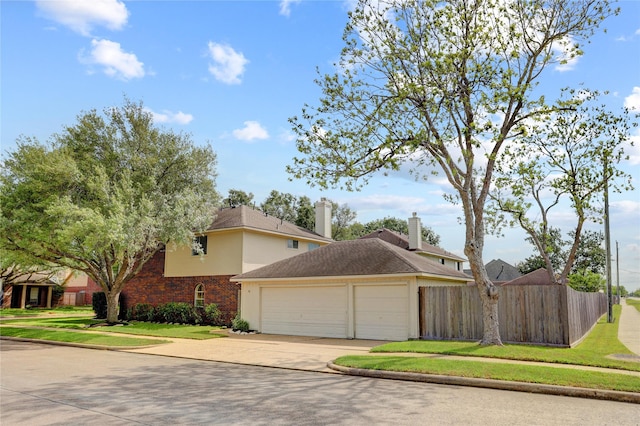 view of home's exterior featuring an attached garage, fence, a yard, and driveway