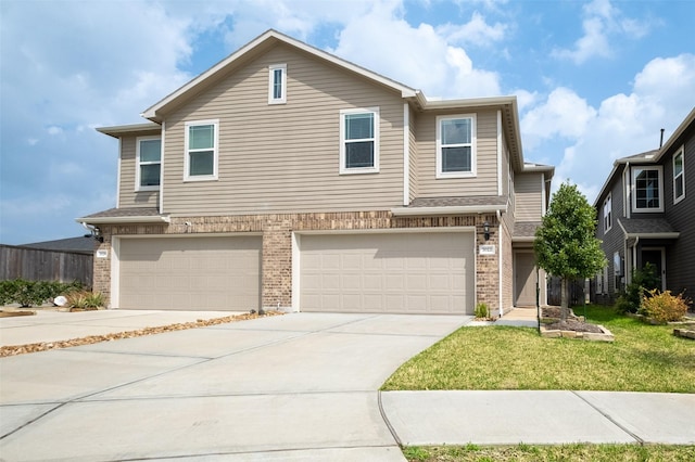 view of front facade with driveway, brick siding, an attached garage, and a front lawn