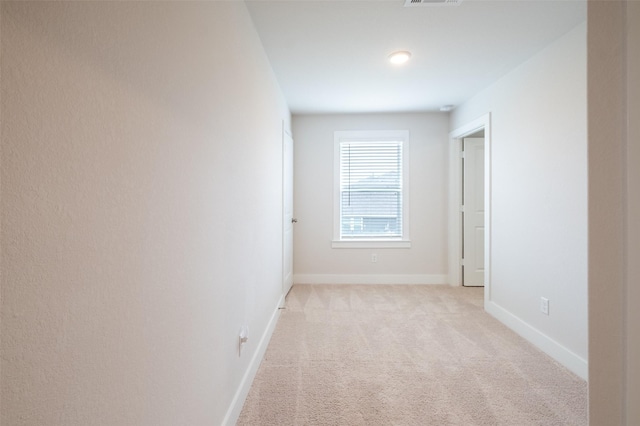 interior space featuring baseboards, light carpet, and visible vents