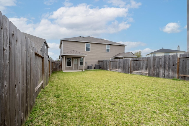 rear view of house featuring a fenced backyard, a patio area, and a yard