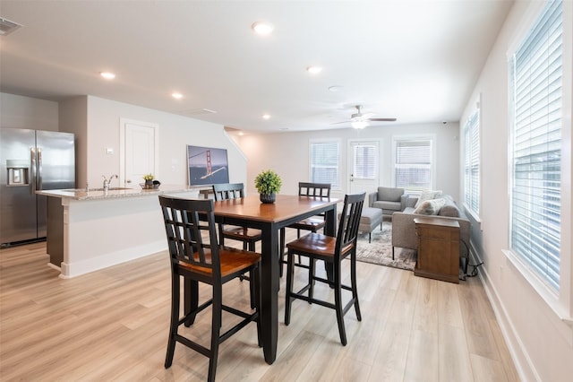 dining area featuring baseboards, light wood-type flooring, and ceiling fan