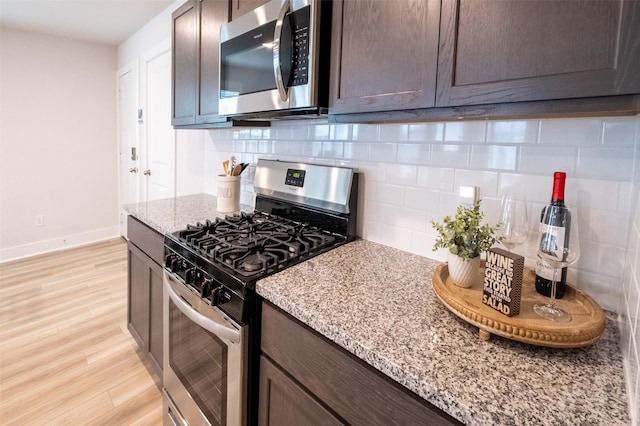 kitchen with tasteful backsplash, dark brown cabinetry, appliances with stainless steel finishes, and light wood finished floors