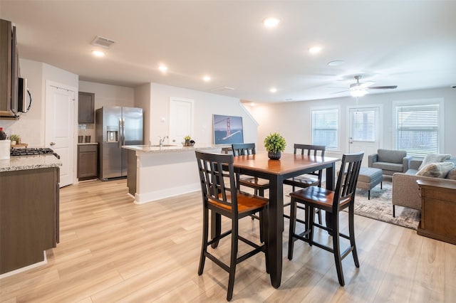 dining room with visible vents, light wood-style flooring, a ceiling fan, recessed lighting, and baseboards