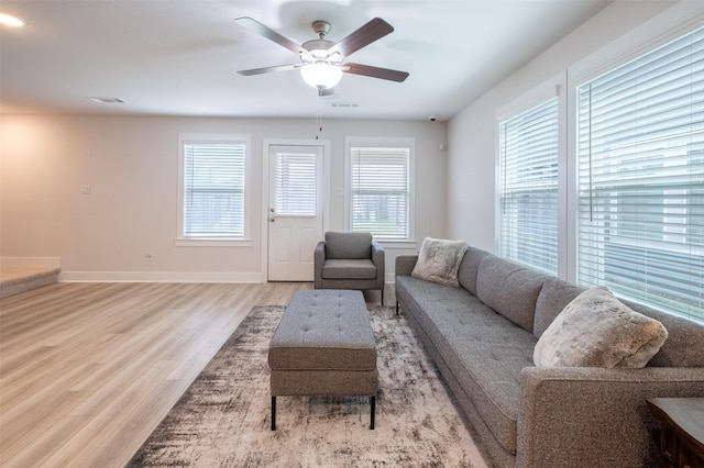 living area featuring ceiling fan, wood finished floors, visible vents, and baseboards