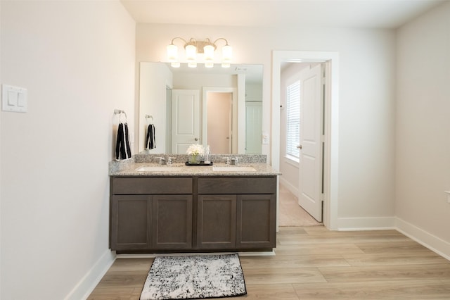 full bathroom featuring wood finished floors, baseboards, and a sink