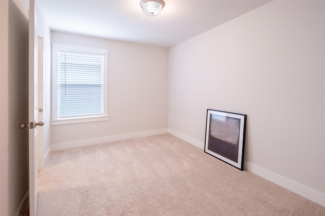 spare room with baseboards and carpet floors