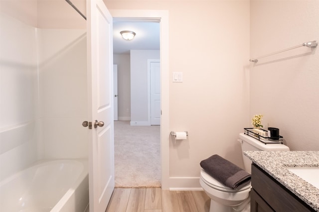 full bathroom featuring baseboards, toilet, wood finished floors, and vanity