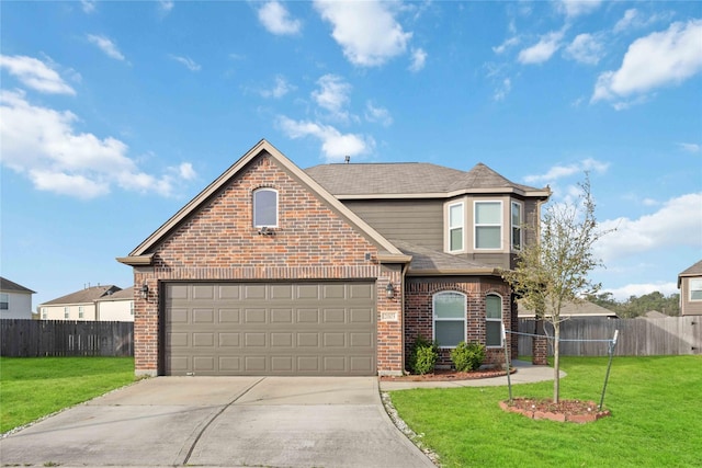 view of front of house with brick siding, concrete driveway, a front yard, and fence