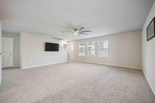 unfurnished living room featuring light colored carpet, baseboards, and a ceiling fan