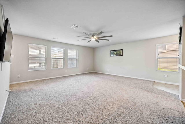 carpeted spare room with visible vents, baseboards, and a ceiling fan