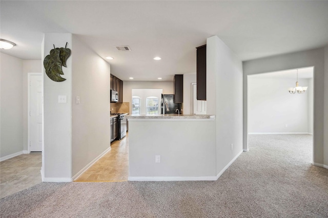 kitchen with visible vents, light carpet, appliances with stainless steel finishes, light countertops, and a chandelier