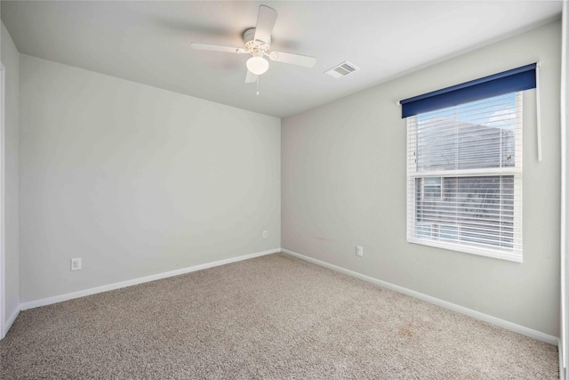 unfurnished room featuring carpet flooring, visible vents, baseboards, and a ceiling fan