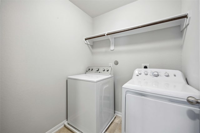 laundry room featuring laundry area, baseboards, and washing machine and clothes dryer