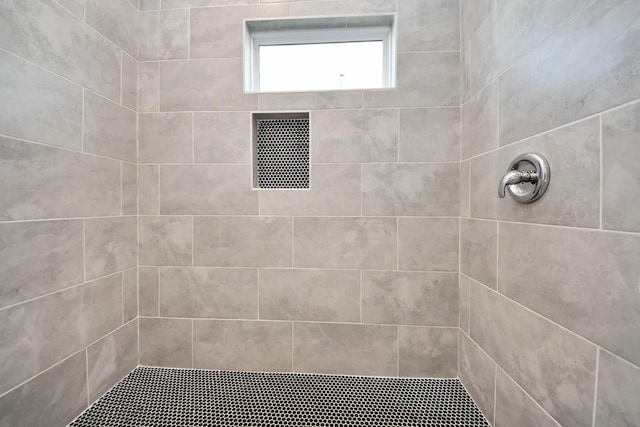 full bath with visible vents and tiled shower