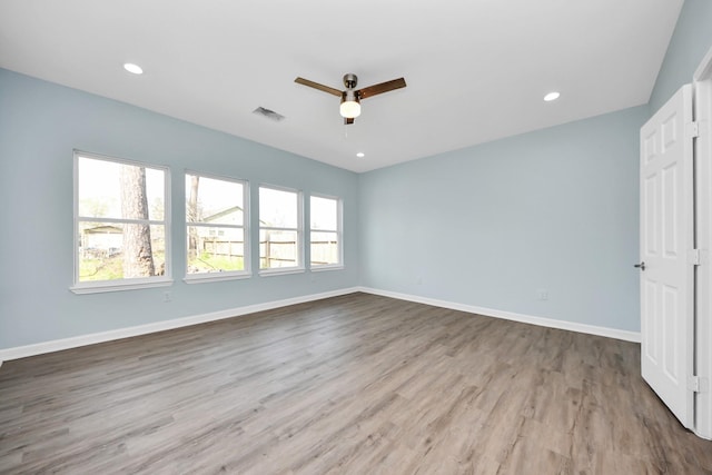 unfurnished room with a ceiling fan, visible vents, a wealth of natural light, and baseboards