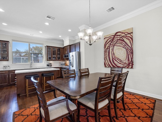 dining space featuring a notable chandelier, visible vents, dark wood-style flooring, and ornamental molding