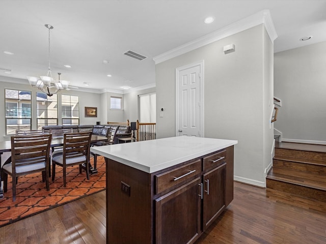 kitchen with visible vents, ornamental molding, dark wood-style floors, light countertops, and a chandelier