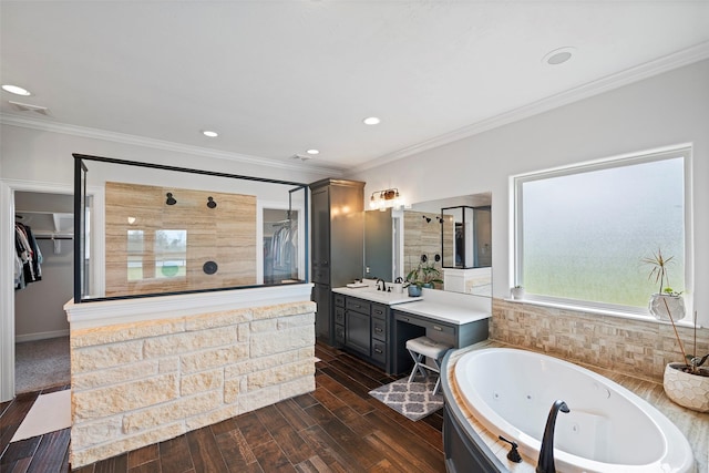 bathroom with a stall shower, a jetted tub, crown molding, and wood finished floors