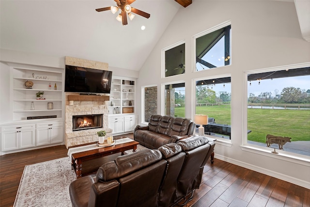 living room with baseboards, built in features, a fireplace, dark wood-style floors, and a ceiling fan