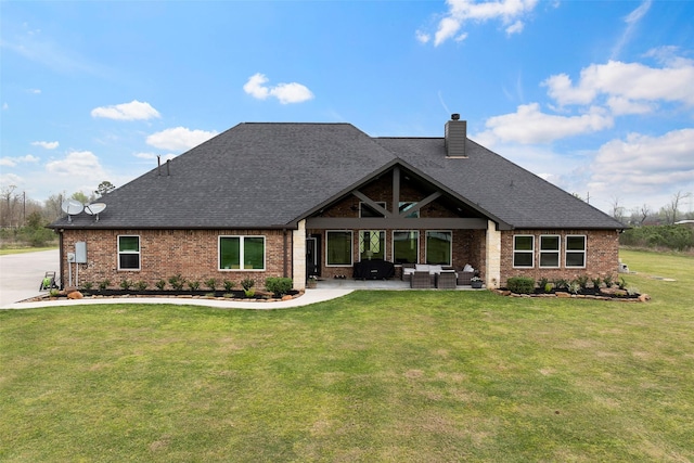 back of house with a patio, a chimney, outdoor lounge area, a lawn, and brick siding